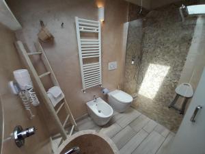 阿尔本加AMA AFFITTACAMERE的浴室配有卫生间、盥洗盆和淋浴。