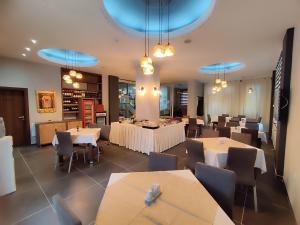 斯科普里普瑞米尔酒店的一间设有白色桌椅和蓝色灯光的餐厅