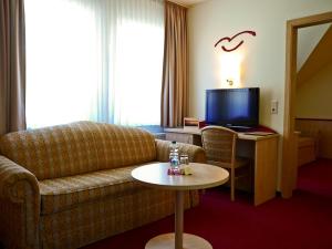 瓦伦远海海洋酒店的客厅配有沙发和带电视的桌子