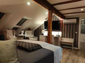乌埃克尔明德AnaCapri Gästehaus Lugano的一间卧室配有一张床、两把椅子和电视