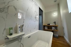 图尔In the beautiful districts of Tours a "particular" with great comfort的白色的浴室设有浴缸和大理石墙。