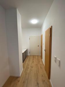 尼尔廷根Wohnung in Nürtingen的一间公寓的空走廊,拥有白色的墙壁和木地板