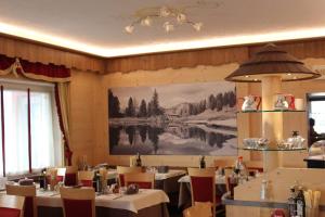 博萨迪法萨艾达酒店的一间设有桌子的用餐室和墙上的大画