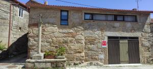 穆罗斯Casa de Canteiro Louro - Muros的石头房子,前面有一扇门