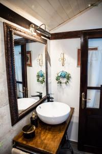 图尔恰Pensiunea Casa Varvara的一间带水槽和大镜子的浴室