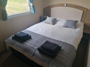 海斯廷斯Sussex by the sea holiday home的一间卧室配有一张大床和两条毛巾