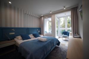 拉塔Pensjonat Przedwiośnie的一间卧室配有一张蓝色床头板的大床