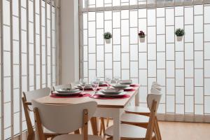 波尔图Júlio de Matos Guest House的用餐室配有带盘子和玻璃杯的桌子