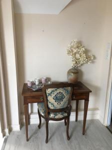 希索LES LAVANDES的一张带椅子的木桌和一个花瓶