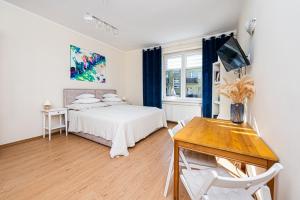 格丁尼亚Apartament Gdynia的一间卧室配有一张床、一张桌子和一张书桌