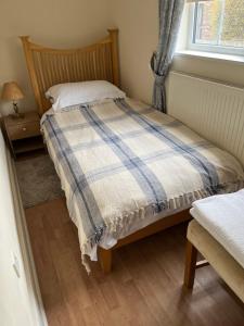 WhittleseyField Cottage的一间卧室配有一张带铺着地毯的床和窗户。