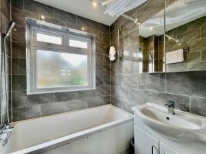 齐格威尔Modern 3 Bed Chigwell House (Free Parking)的带浴缸、水槽和窗户的浴室