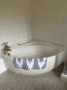 WhittleseyField Cottage的浴室内提供白色浴缸及毛巾