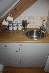 索尔兹伯里Scotland Lodge Farm, Stonehenge的厨房柜台配有水槽和白色橱柜