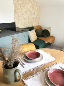 瓦讷Gîte Loufiosa Vannes的客厅配有带盘子的桌子和沙发