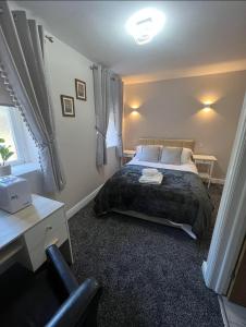 WingateThe Railway Crossings的一间卧室配有一张床、一张桌子和一把椅子