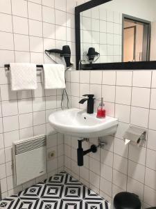 维也纳Apartman Favorita的白色的浴室设有水槽和镜子