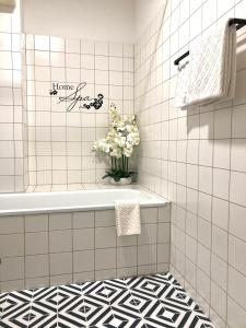 维也纳Apartman Favorita的带浴缸和花瓶的浴室