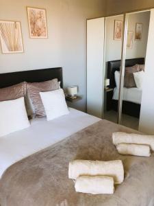 洛斯杜尔斯Résidence Saradon La Zenia Boulevard的一间卧室配有一张大床和两条毛巾