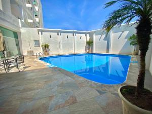 莱昂Hotel Enterprise Inn Poliforum的棕榈树庭院里的一个大型蓝色游泳池