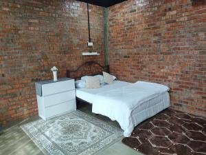 Permatang PauhStudio Amani Permatang Pauh的卧室设有砖墙和白色的床