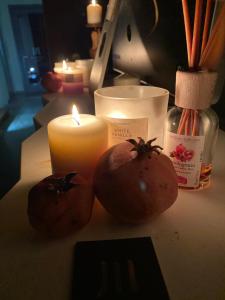 贡内萨LUVIA ROOMS SPA的桌子上放着两个西红柿和蜡烛