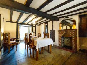 斯托马基特Laburnham Cottage的一间带桌子和壁炉的用餐室