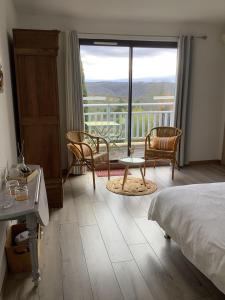 卡尔斯Les Etoiles de Calès的一间卧室配有一张床铺和椅子,设有一个阳台