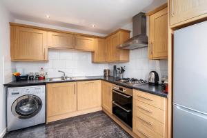 谢菲尔德Stunning 3BD Home Hillsborough Sheffield的厨房配有木制橱柜、洗衣机和烘干机