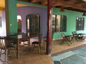 诺萨拉Villa Tortuga的一间拥有绿色墙壁和木桌及椅子的用餐室