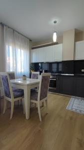 地拉那Tirana New Bazaar- Apartment no-1的厨房配有白色的桌椅