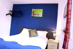 布莱克浦Calypso hotel Blackpool的一间卧室设有蓝色的墙壁和一张床