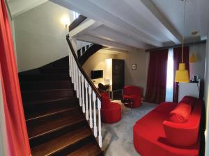 特罗吉尔十二世纪遗产酒店的一间带楼梯和红色沙发的客厅