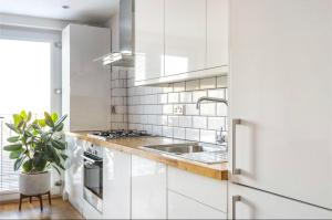 布罗姆利No.1 Universal House - Double Bedroom Apartment的白色的厨房配有白色橱柜和水槽