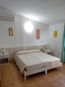 穆拉沃拉Il Falconiere的一间白色卧室,配有床和2个床头柜