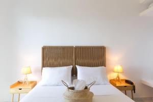 斯卡拉Koukounari Apartments的一间卧室配有一张带白色床单和两盏灯的床。