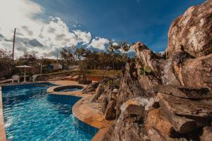 迪亚曼蒂纳SO HAM Guest House的一座带岩石墙的度假村内的游泳池