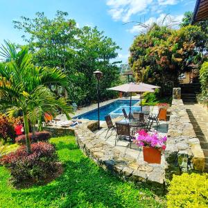 圣希尔Hotel Casas de Campo El Ciruelo的后院设有游泳池和带遮阳伞的桌子