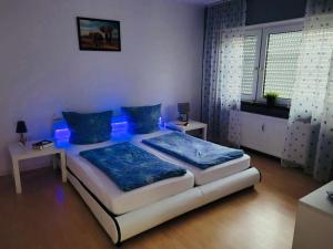 瓦尔多夫Appartment in Walldorf mit Schlafzimmer, Küche und Bad的一间卧室配有一张蓝色灯床