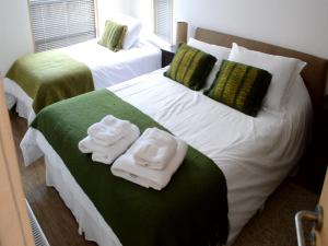 蓬塔阿雷纳斯奇岚格公寓式酒店的两间带毛巾的床(位于酒店客房内)