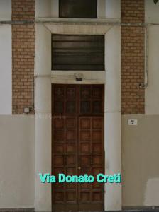 博洛尼亚Via Creti & Via Mazza Rooms的建筑上一扇带窗户的棕色门