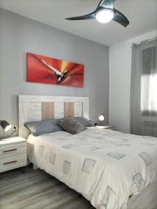 布拉内斯Casa junto al mar的卧室配有一张白色床,墙上挂有绘画作品