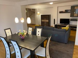 MogoşoaiaDuplex 145mp, 2+1 camere, 3 bai的客厅配有桌子和蓝色沙发