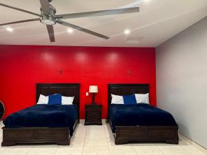诺加利斯Casa de campo con vistas espectaculares的红色墙壁的客房内的两张床