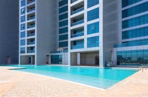 阿吉曼Walk to the Beach, Charming 3-Bedroom Home in Ajman Corniche Residences的大楼前的游泳池