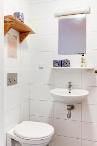 阿姆斯特丹珂珂玛玛旅舍的白色的浴室设有卫生间和水槽。