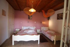帕莱欧卡斯提撒Niky's cottage的卧室配有白色的床和粉红色的墙壁
