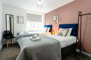 泰恩河畔纽卡斯尔Fab 2bedroom apartment- Free parking, 5mins from city centre, Portland Rd NE2 1DJ的配有两张粉红色和蓝色床铺的客房