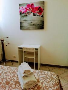 佛罗伦萨Apartement NICKY的一间卧室配有一张床和一张带毛巾的书桌