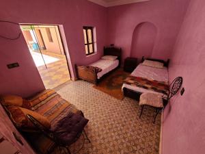 拉拉塔可库斯特Dar de l'Atlas的紫色的客房配有两张床和一把椅子